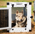 Working dog resting calmly inside a white Robust crate with the Anti-Stress Door.