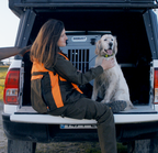 Hunter with a Golden Retriever beside a Robust dog crate in a pick-up truck.