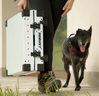 Hunter carrying a folded white Robust dog crate with a black dog at their side.