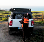 Robust dog crate loaded in the back of a pick-up truck in the countryside.