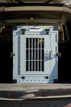 Front view of the grey Robust collapsible dog crate installed in the boot of a car.